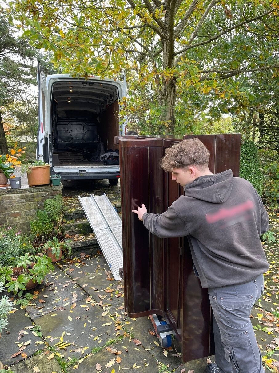 Piano being loaded for collection and recycling