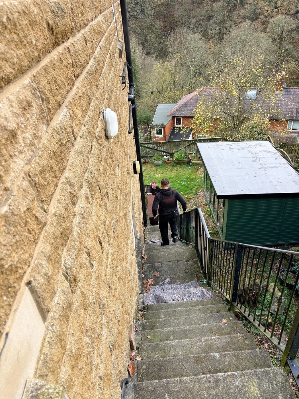Piano being moved down a flight of outside steps for disposal in Yorkshire