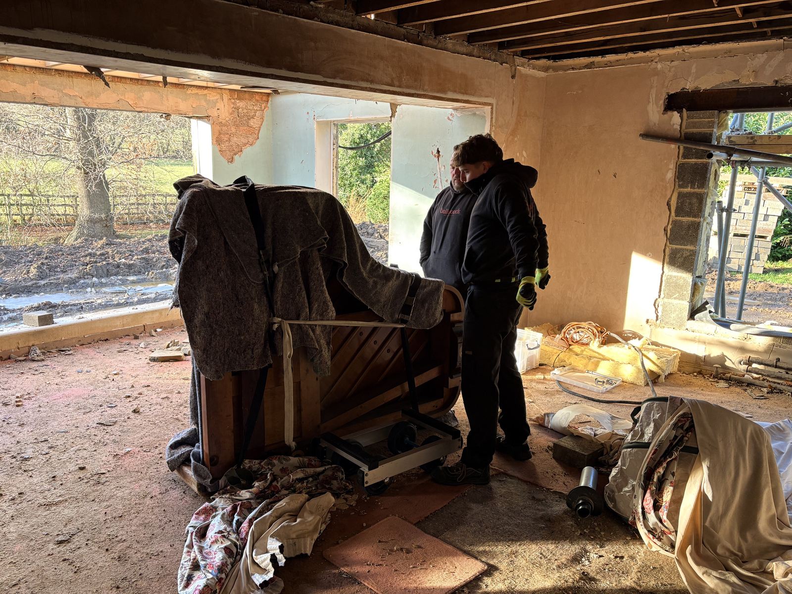 Upright piano moved out of a rural property under renovation