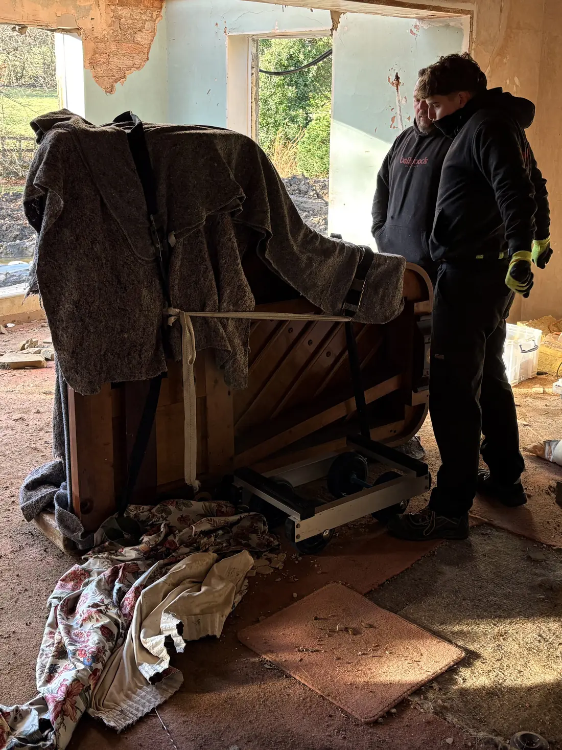 Upright piano moved out of a rural property under renovation