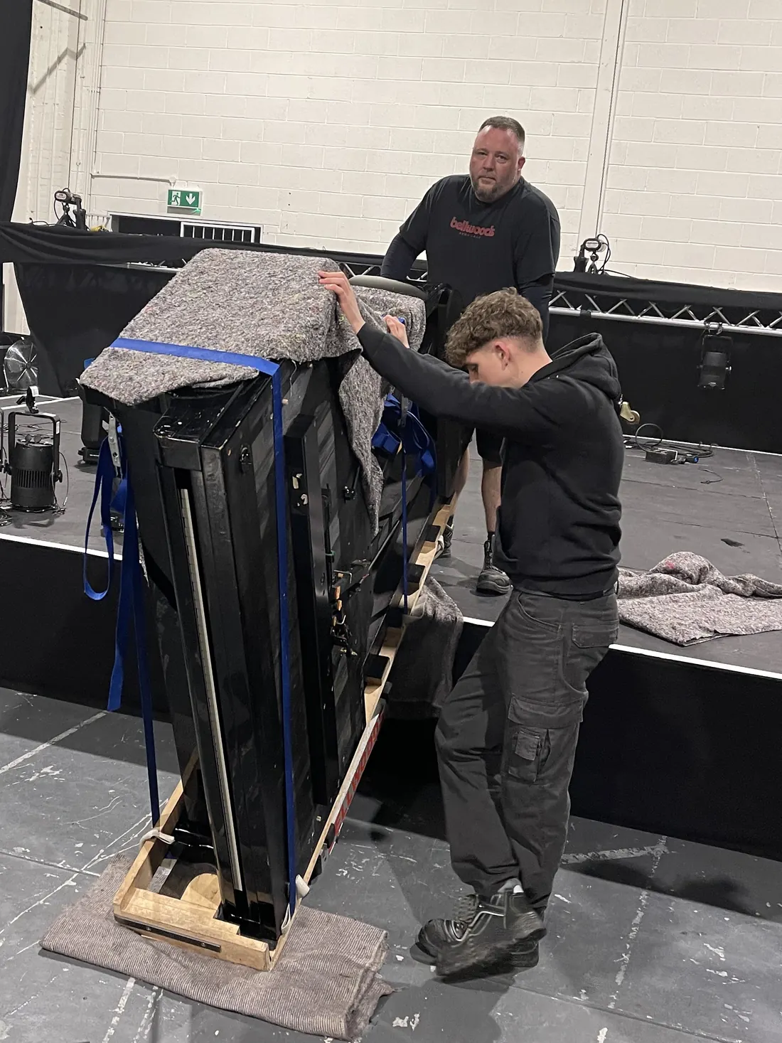 Piano strapped to a skid board for a venue move